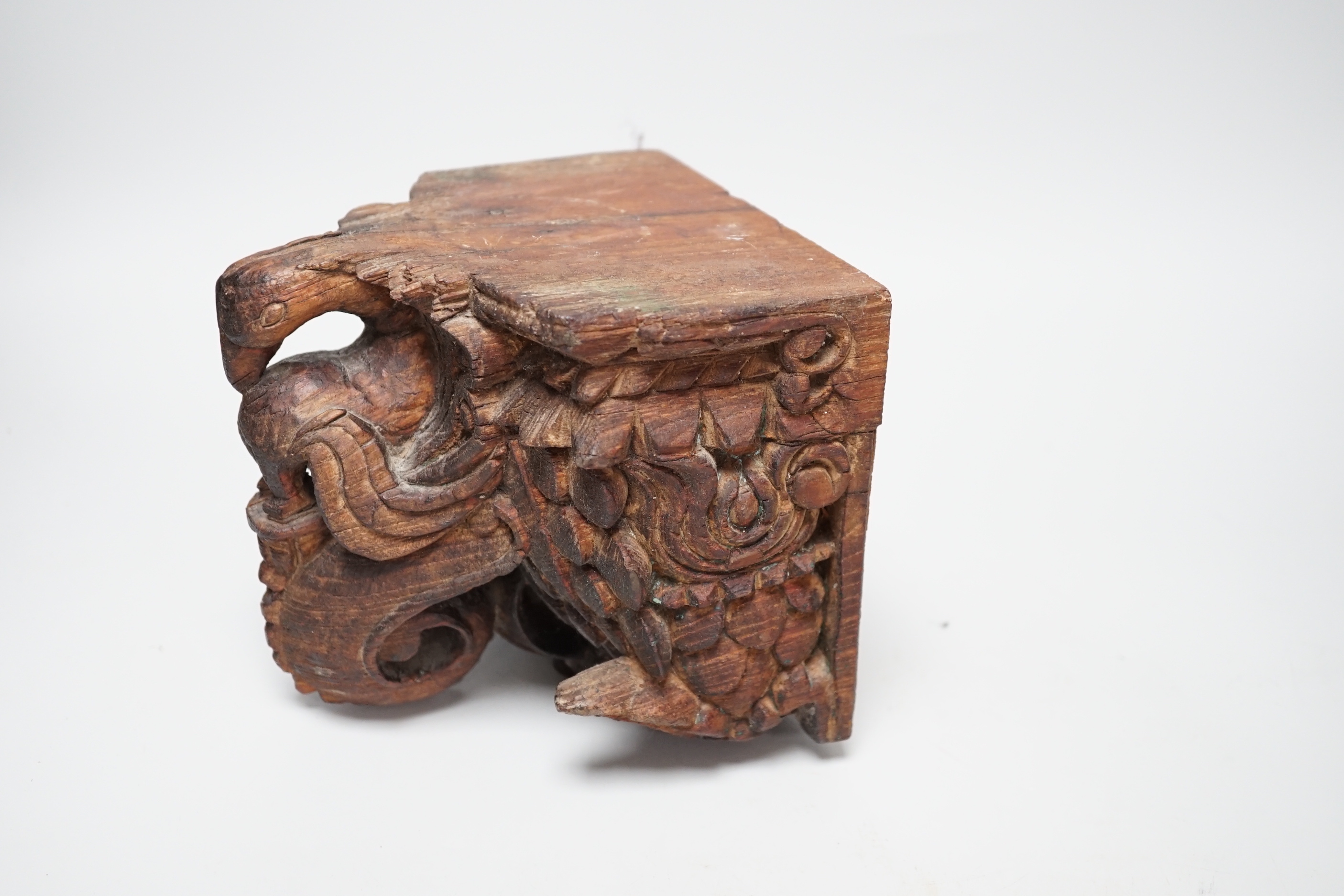 A carved South East Asian hardwood temple lion and an Indian wall bracket (2) tallest 23cm